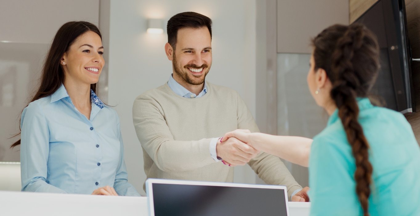 couple talking with front desk